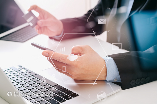 商人在网上购买信用卡在现代服务台用移动电话和膝上型计算机VR图标